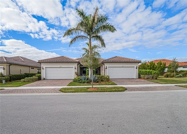 5190 Unity Sq, Vero Beach, FL 32967 - mediterranean / spanish-style house with an attached garage, decorative driveway, stucco siding, and a tile roof