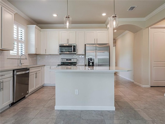 5190 Unity Sq, Vero Beach, FL 32967 - kitchen with appliances with stainless steel finishes, ornamental molding, backsplash, light countertops, and arched walkways