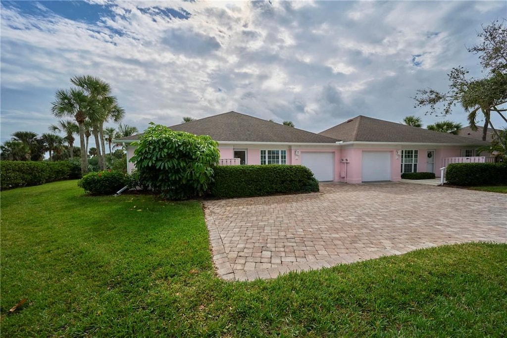 single story home featuring a garage and a front lawn