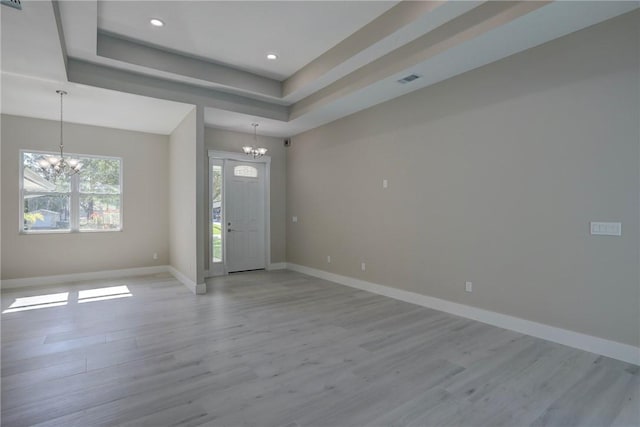 7985 99th Ave, Vero Beach, FL 32967 - foyer entrance featuring a chandelier, light wood-style flooring, a tray ceiling, and recessed lighting