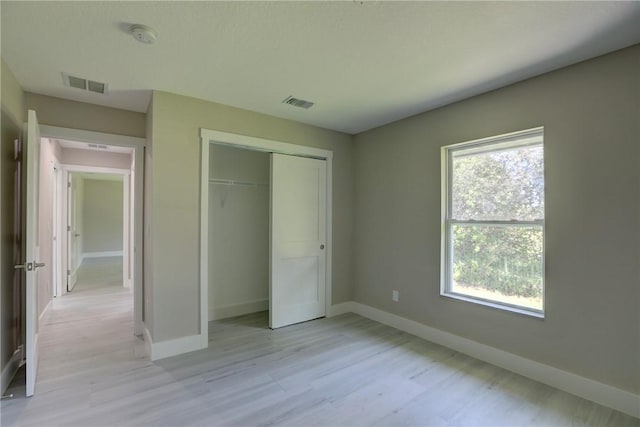 7985 99th Ave, Vero Beach, FL 32967 - unfurnished bedroom featuring light wood-type flooring and a closet