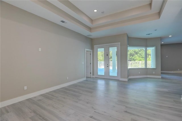 7985 99th Ave, Vero Beach, FL 32967 - unfurnished room with french doors, light wood finished floors, recessed lighting, and a tray ceiling