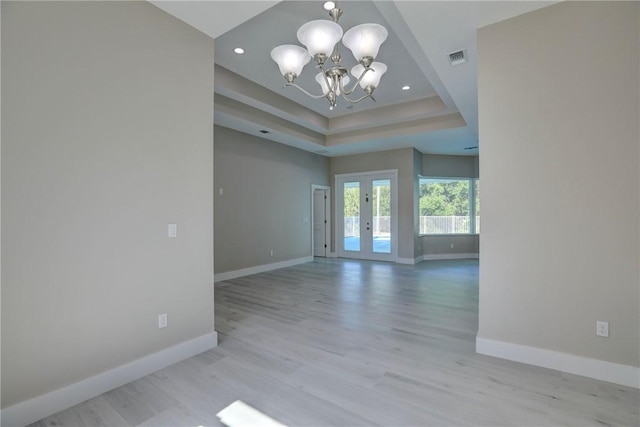 7985 99th Ave, Vero Beach, FL 32967 - spare room featuring a chandelier, french doors, a tray ceiling, light wood-type flooring, and recessed lighting