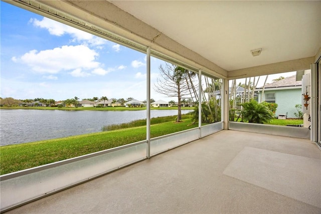 unfurnished sunroom with a residential view, a water view, and a wealth of natural light