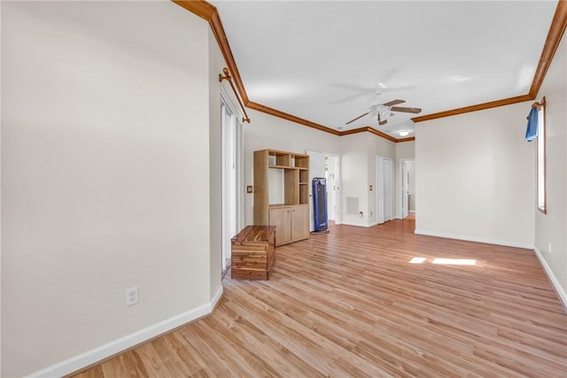 spare room featuring light wood-style flooring, a ceiling fan, crown molding, and baseboards