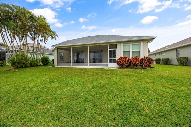 rear view of property featuring a yard and a sunroom