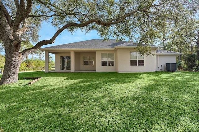 back of house with a lawn and central AC