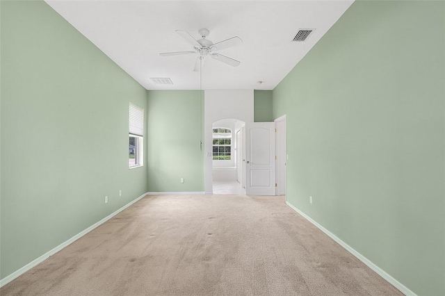 carpeted spare room featuring ceiling fan