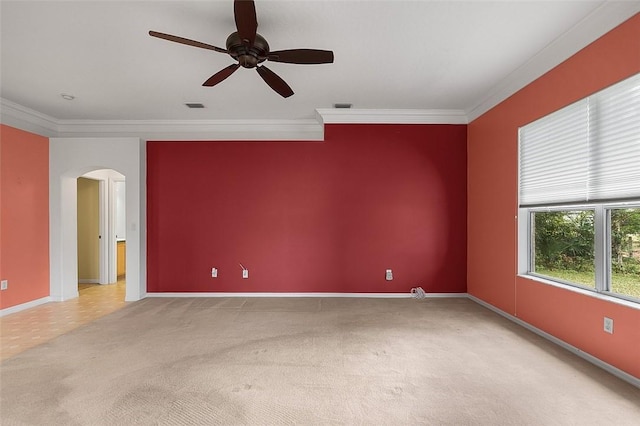 carpeted empty room with ceiling fan and crown molding