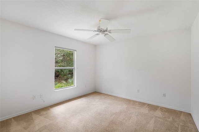 unfurnished room featuring light carpet and ceiling fan