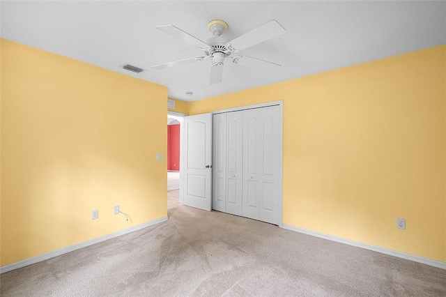 unfurnished bedroom featuring light carpet, a closet, and ceiling fan