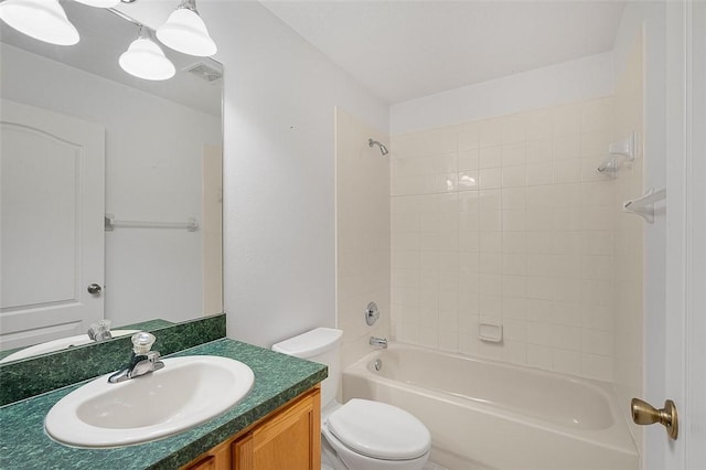 full bathroom featuring vanity, tiled shower / bath, and toilet