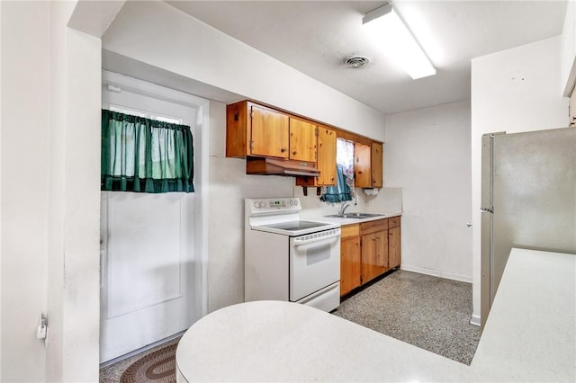 kitchen featuring white electric stove, stainless steel refrigerator, and sink