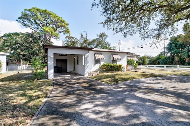 view of front of home with a front lawn and a carport