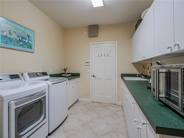 washroom with cabinets, separate washer and dryer, sink, and a textured ceiling