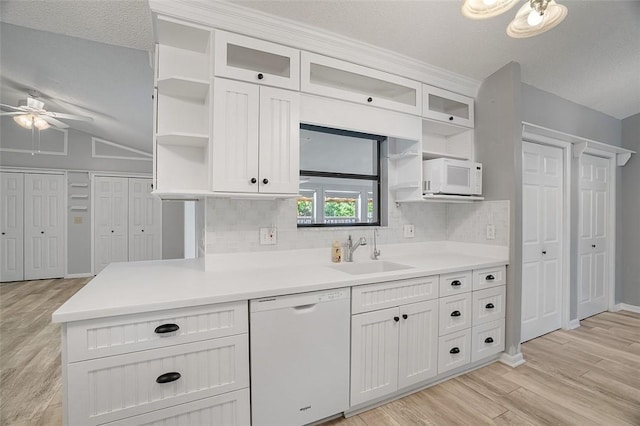 kitchen with sink, white appliances, light hardwood / wood-style flooring, tasteful backsplash, and white cabinets