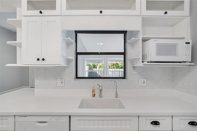 kitchen featuring white cabinetry, white appliances, sink, and tasteful backsplash