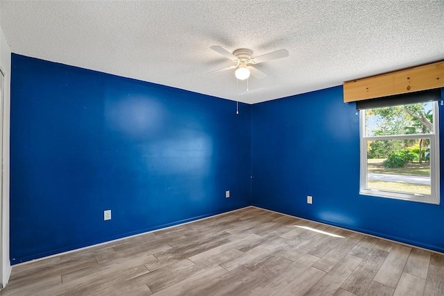 spare room with a textured ceiling, ceiling fan, and light hardwood / wood-style flooring