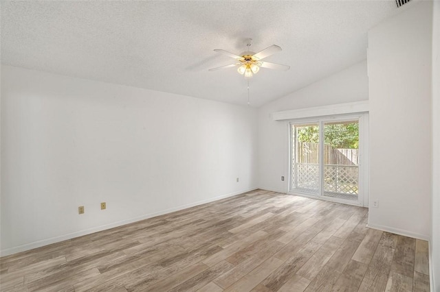 spare room featuring ceiling fan, lofted ceiling, a textured ceiling, and light hardwood / wood-style floors