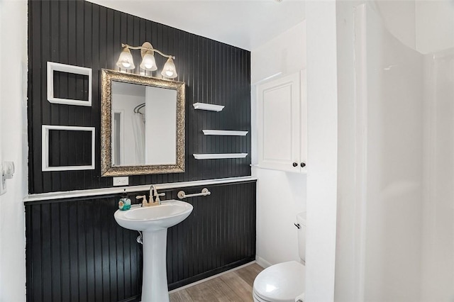 bathroom featuring walk in shower, toilet, and hardwood / wood-style floors