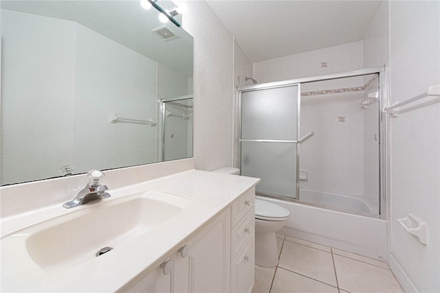 full bathroom featuring vanity, a textured ceiling, bath / shower combo with glass door, tile patterned flooring, and toilet