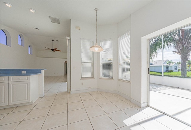 unfurnished dining area featuring light tile patterned flooring and ceiling fan