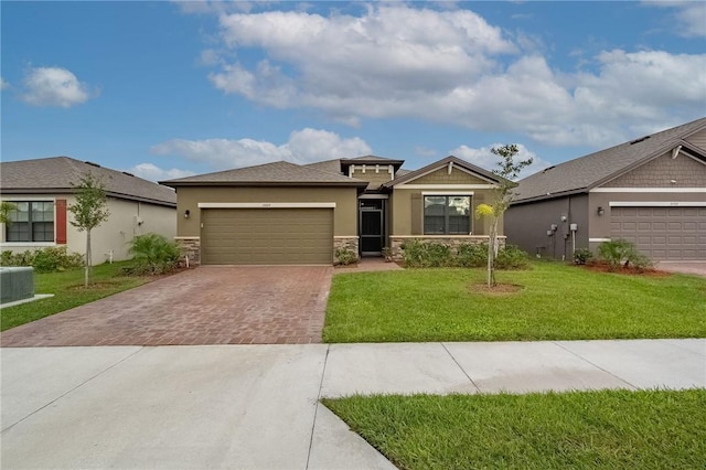 view of front of property featuring a front yard, a garage, and central air condition unit