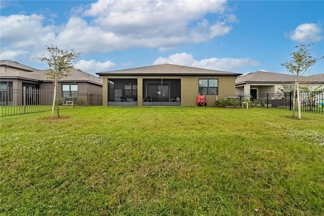 back of property featuring a sunroom and a lawn