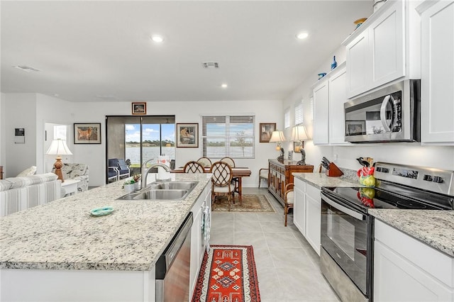 kitchen featuring appliances with stainless steel finishes, a center island with sink, white cabinetry, and sink