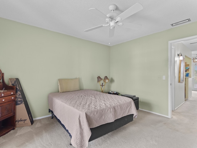 carpeted bedroom featuring a textured ceiling and ceiling fan