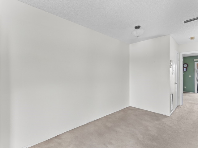 carpeted spare room with a textured ceiling