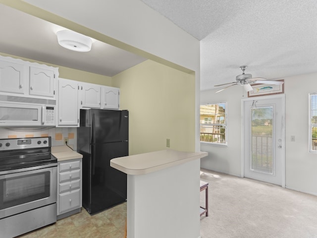 kitchen featuring black refrigerator, a breakfast bar, white cabinets, kitchen peninsula, and stainless steel electric stove