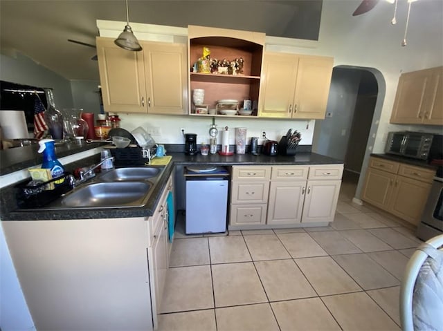 kitchen with light tile patterned flooring, sink, hanging light fixtures, dishwashing machine, and ceiling fan