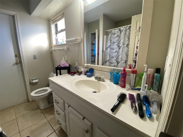 bathroom featuring vanity, toilet, and tile patterned flooring