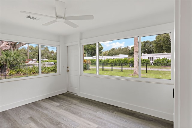 unfurnished sunroom with ceiling fan