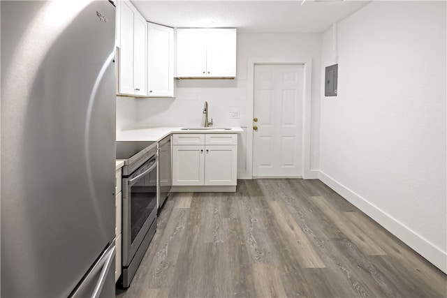 kitchen featuring white cabinets, hardwood / wood-style flooring, appliances with stainless steel finishes, and sink