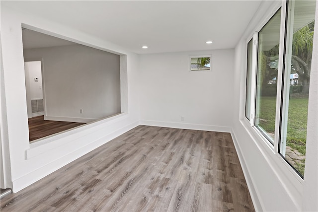 unfurnished room featuring light hardwood / wood-style floors and plenty of natural light