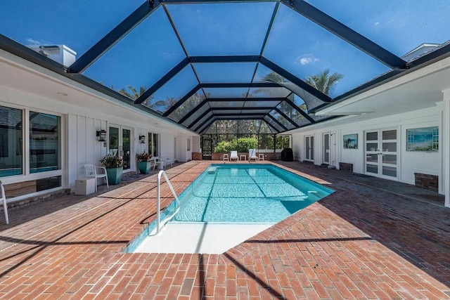 pool featuring glass enclosure, a patio, and french doors