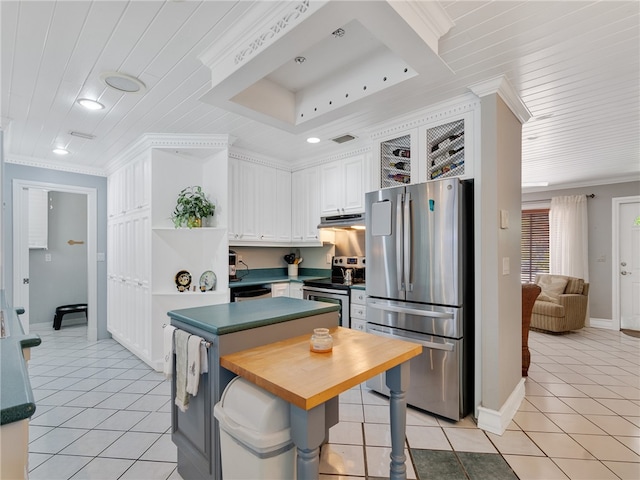 kitchen featuring crown molding, light tile patterned floors, white cabinets, under cabinet range hood, and stainless steel appliances
