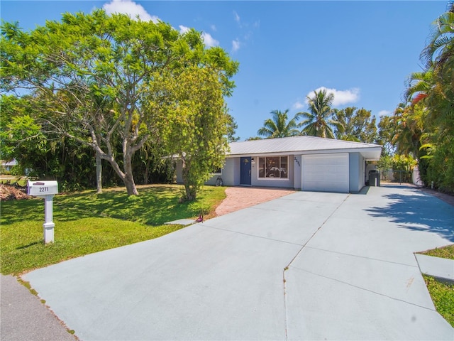 ranch-style house featuring a garage, a front lawn, metal roof, and concrete driveway