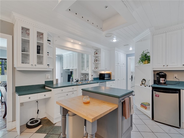 kitchen featuring fridge, open shelves, black microwave, a sink, and ornamental molding