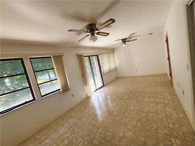 spare room featuring tile patterned floors and ceiling fan