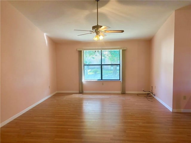 unfurnished room with light wood-type flooring, baseboards, and a ceiling fan