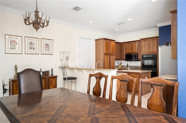 dining area with ornamental molding, sink, and an inviting chandelier