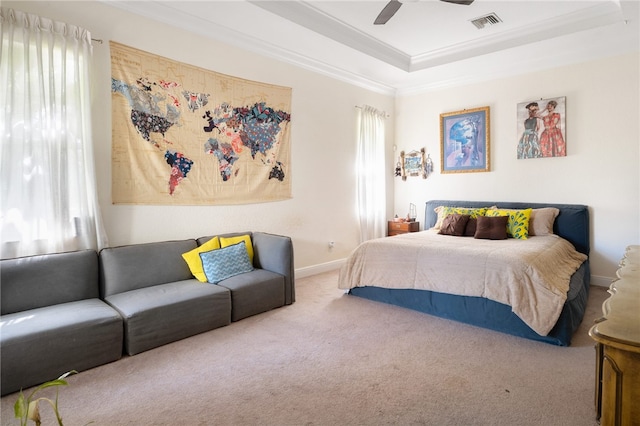 bedroom with ornamental molding, carpet, ceiling fan, and a raised ceiling