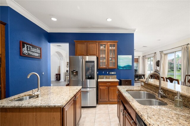 kitchen featuring an island with sink, stainless steel fridge with ice dispenser, sink, and crown molding