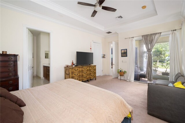 bedroom with access to outside, light colored carpet, ensuite bathroom, ceiling fan, and a tray ceiling