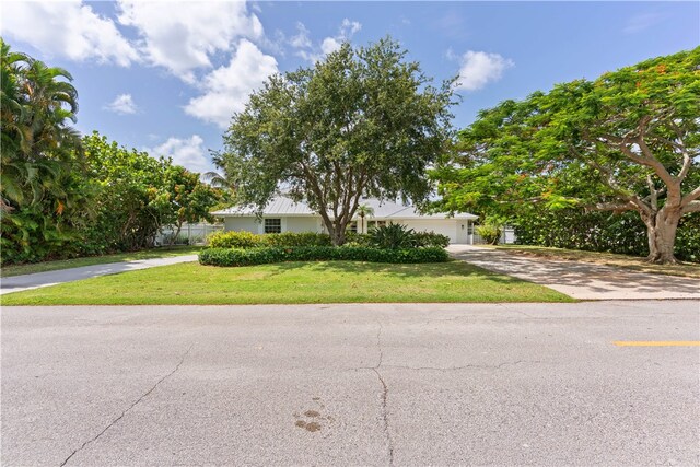 25 Park Ave, Vero Beach, FL 32960 - view of front of property with a front yard, concrete driveway, and a garage
