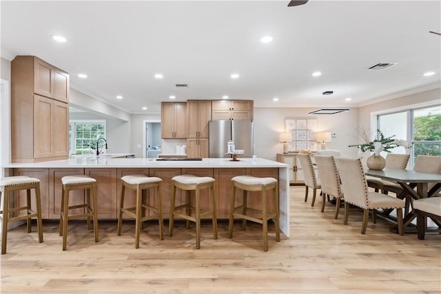 25 Park Ave, Vero Beach, FL 32960 - kitchen with freestanding refrigerator, crown molding, light wood-style flooring, a peninsula, and plenty of natural light
