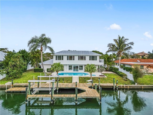25 Park Ave, Vero Beach, FL 32960 - back of property with boat lift, a water view, an outdoor pool, metal roof, and a patio area